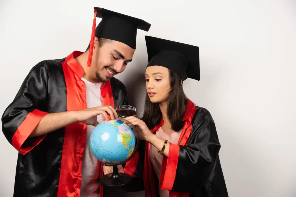 para-szczesliwych-studentow-w-sukni-patrzac-na-swiecie-na-bialym-tle